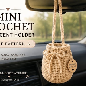Può includere: Un porta profumatore per auto in uncinetto beige con chiusura a coulisse e un'etichetta rotonda in legno con la scritta "HANDMADE WITH LOVE" e un'icona a forma di cuore. Il testo "MINI CROCHET CAR SCENT HOLDER PDF PATTERN" e "GENTLE LOOP ATELIER" è visibile.