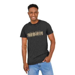 Pode incluir: Uma t-shirt de manga curta cinzento-carvão com um gráfico bege desgastado no peito. O gráfico apresenta o texto ENKIDU ARCHIVE acima de um design de código de barras com os números 3 6 9 3 4 5 6 7 8 9 0 1 1 impressos por baixo.