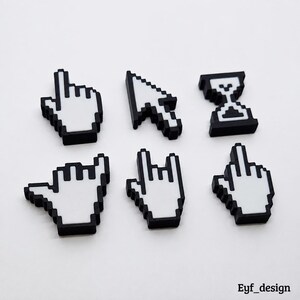 May include: A set of six pixelated computer cursor charms in white and black. The shapes include a pointing finger, a standard arrow pointer, an hourglass, a shaka hand sign, a rock-and-roll hand gesture, and a middle finger. Text reads Eyf_design.