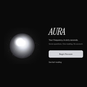 Può includere: Un'interfaccia digitale su sfondo nero con una sfera bianca luminosa. Il testo recita: AURA, Your frequency, in sixty seconds. Seven questions. One reading. No account. Un pulsante con la scritta Begin the scan e un link See last reading.