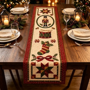 Könnte beinhalten: Ein rechteckiger, gesteppter Tischläufer mit einem cremefarbenen Mittelteil, der ein wiederkehrendes Muster aus einem Nussknacker, einer Trommel, einem Weihnachtsstrumpf und Sternen zeigt, umrandet von einer rot-grünen Bordüre.