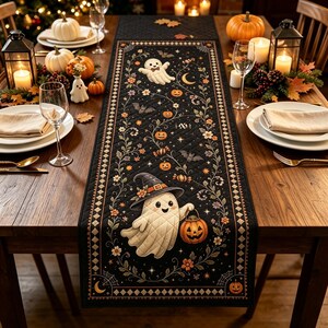 Peut inclure: Un chemin de table matelassé noir orné d'un motif répétitif de fantômes blancs, de citrouilles orange, de chauves-souris et de vignes fleuries. Il présente une bordure en losanges et un fantôme portant un chapeau de sorcière tenant une citrouille.