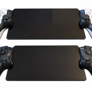 Può includere: Due console di gioco portatili con controller integrati su entrambi i lati. Il dispositivo superiore presenta impugnature bianche e nere con pulsanti direzionali e joystick standard. Il dispositivo inferiore è interamente nero con comandi abbinati.