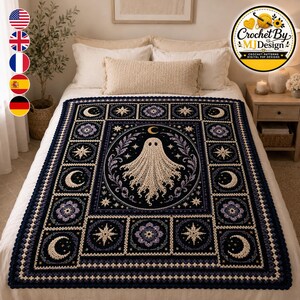 May include: A rectangular crochet blanket featuring a central cream-coloured ghost motif surrounded by a dark navy blue border. The design includes repeating square panels with light purple floral patterns, crescent moons, and starburst shapes.