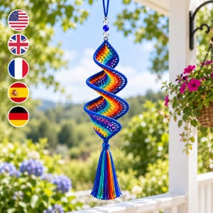 May include: A spiral-shaped crochet hanging ornament featuring a vibrant rainbow gradient of red, orange, yellow, green, blue, and purple yarn. The structure is suspended by a blue cord with clear beads and terminates in a long, multi-colored tassel.