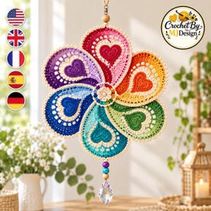 May include: A hanging crochet suncatcher featuring a six-petaled flower design in a rainbow gradient of red, orange, yellow, green, blue, and purple. Each petal contains a heart motif, with a central cream flower and a dangling clear crystal prism.