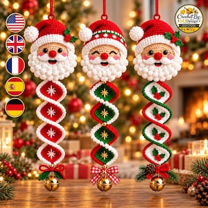 Könnte beinhalten: Drei gehäkelte Weihnachtsmann-Ornamente mit spiralförmigen Schwänzen. Jeder Weihnachtsmann hat eine rote Mütze, einen weißen Bart und rosige Wangen. Die Schwänze zeigen rote, weiße und grüne geometrische Muster mit gestickten Sternen oder Stechpalmen und enden in einer goldenen Glocke.