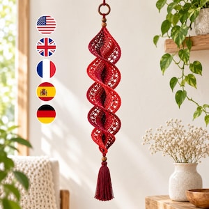 May include: A red crochet hanging ornament featuring a spiraling, openwork lace design. The piece is suspended from a dark wooden ring and a small wooden bead, and it terminates in a long, matching red fiber tassel with a wooden bead accent.