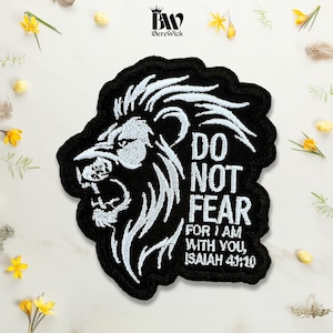 May include: A black embroidered patch featuring a white profile of a roaring lion head on the left side. To the right, the white embroidered text reads: DO NOT FEAR FOR I AM WITH YOU, ISAIAH 41:10. The patch has a thick black stitched border.