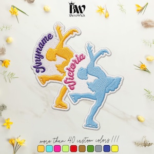 May include: Two embroidered patches featuring ice skaters in motion. One patch is yellow with the purple text "Anyname" and the other is light blue with the pink text "Victoria". Both patches have a white background and detailed stitching.