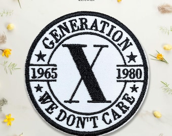 May include: A circular embroidered patch featuring a white background with a thick black border. The text GENERATION X is arched at the top, with WE DON'T CARE at the bottom. A large black letter X sits in the center, flanked by 1965 and 1980.