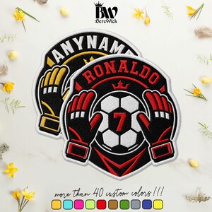 May include: Two embroidered football patches featuring a central football with the number 7, flanked by two goalkeeper gloves. The top of the patch displays the name RONALDO in red text. The design includes a crown icon and black, red, and white colours.