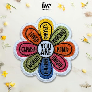 May include: A flower-shaped embroidered patch with a white center featuring the text YOU ARE. The petals are yellow, green, orange, pink, and blue, each containing the black embroidered words STRONG, IMPORTANT, KIND, UNIQUE, ENOUGH, WORTHY, CAPABLE, and LOVED.