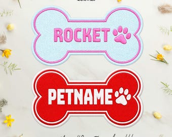 Puede incluir: Dos parches bordados con forma de hueso. El parche superior es azul claro con borde rosa, el texto ROCKET y una huella rosa. El parche inferior es rojo con borde blanco, el texto PETNAME y una huella blanca. El logotipo BereWick está arriba.
