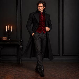 May include: A long black overcoat worn over a deep red velvet vest and a matching red necktie. The ensemble includes black trousers and black leather boots, creating a formal appearance with a structured collar and buttoned details.