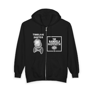 Peut inclure: Un sweat à capuche zippé noir avec des motifs graphiques blancs. Le côté gauche affiche le texte TIMELINE SHIFTER au-dessus d'un design en fil de fer en forme de spirale et de sablier. Le côté droit présente un cadre carré avec le texte THE MANDELA EFFECT.