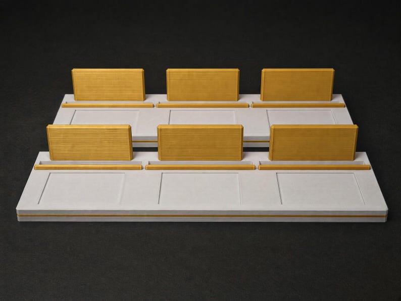 May include: Two rectangular white display bases, each featuring three raised yellow wooden rectangular panels and three corresponding yellow horizontal slots. The white bases have a smooth, flat surface with recessed rectangular outlines.
