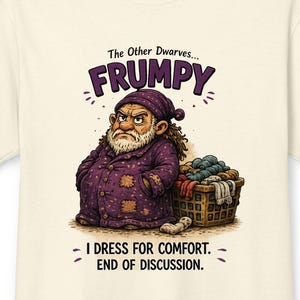 May include: A cream-colored t-shirt featuring a graphic of a grumpy dwarf in purple pajamas standing next to a laundry basket. The text reads: The Other Dwarves... FRUMPY. I DRESS FOR COMFORT. END OF DISCUSSION. The design includes patches on the clothing.