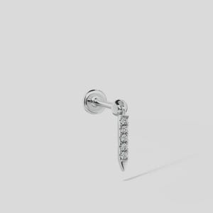 May include: A silver-toned labret stud earring featuring a flat circular back and a vertical bar attachment. The bar is set with five small, clear, round-cut stones arranged in a straight line, extending downward from the main post connection.