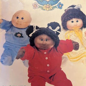 May include: Image of three Cabbage Patch Kids dolls. One doll is wearing a red onesie, another is in a blue outfit, and the third doll is wearing a yellow dress. The dolls have soft, round faces and are positioned against a background with text.