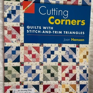 Może przedstawiać: Okładka książki z kolorowym wzorem patchworkowym z czerwonymi, niebieskimi i zielonymi kwadratami. Tytuł to "Cutting Corners: Quilts with Stitch-and-Trim Triangles" autorstwa Joan Hanson.