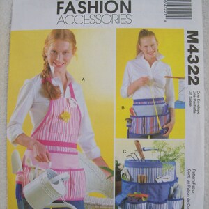 May include: A sewing pattern for a gardening apron, a gardening belt, and a gardening tote. The pattern is called McCall's Fashion Accessories M4322. The apron is pink and white striped with pockets. The belt is blue and white striped with pockets. The tote is blue and white striped with multiple pockets.