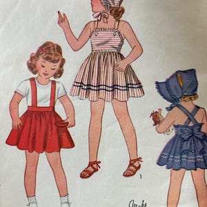 May include: A vintage sewing pattern for three children's dresses. The pattern includes a red and white striped dress, a red skirt with a white top, and a blue dress with a white top. The pattern is labeled "Simple to Make" and includes instructions for making the dresses.