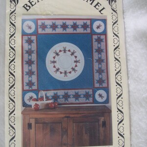 May include: A vintage quilt pattern featuring a red, white, and blue design with a bear and the text "Bear Brummel" and "A Hearthsewn Pattern".