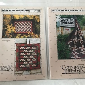Peut inclure: Deux feuilles d'instructions de modèle de courtepointe avec le titre "Delectable Mountains" et le logo Country Threads. La première feuille montre un bloc de courtepointe avec un motif de chaîne de montagnes et la deuxième feuille montre une courtepointe avec un motif de chaîne de montagnes.