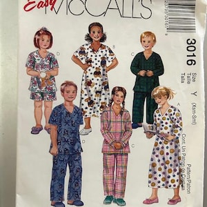 May include: A sewing pattern for children's pajamas. The pattern includes five different styles of pajamas, including a long-sleeved nightgown with a smiley face print, a long-sleeved pajama set with a plaid print, a short-sleeved pajama set with a baseball print, a long-sleeved pajama set with a teddy bear print, and a short-sleeved pajama set with a floral print. The pattern is for sizes X-Small to Small.