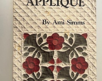 May include: A vintage book titled "Invisible Applique" by Ami Simms. The cover displays a quilted design with a diamond pattern and a floral applique in red, green, and brown. The book appears to be a guide for quilting.
