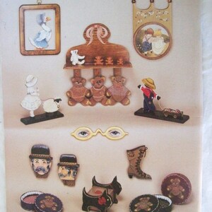 May include: A collection of wooden painted figurines, including a goose, a girl with a lamb, three teddy bears, a boy pulling a wagon, two men's faces, a boot, a dog, and a teddy bear in a round box.