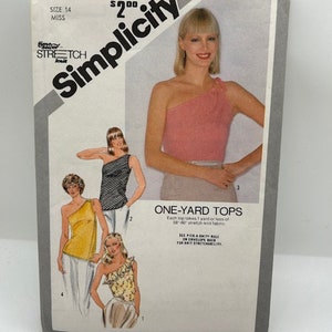 May include: Simplicity sewing pattern number 9972 for one-yard tops. The pattern is for size 14 miss and features four different tops with one-shoulder designs. The tops are shown in various colors and fabrics, including black and white striped, yellow, pink, and floral print.