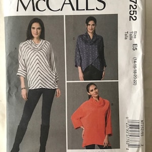 May include: Sewing pattern for a cowl neck top with long sleeves. The pattern is from McCall's and is size E5 (14-16-18-20-22). The pattern shows three different versions of the top, one with black and white stripes, one with a blue floral print, and one in solid orange.