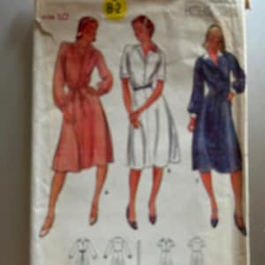 May include: A vintage sewing pattern for a dress, featuring three different styles. The pattern is from Butterick and is size 10. The dress styles include a pink dress with a belt, a white dress with a button-up front, and a blue dress with a wrap-style front.
