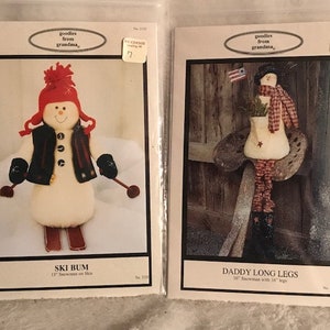 May include: Two vintage sewing patterns for making snowman dolls. The first pattern is for a snowman on skis, titled "Ski Bum" and the second pattern is for a snowman with long legs, titled "Daddy Long Legs".