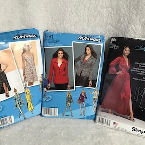 May include: Three sewing patterns for dresses, jackets, and tops. The patterns are from Project Runway and Simplicity. The patterns are on a white background.