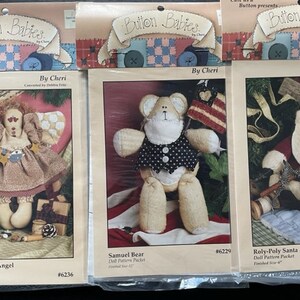 Op de afbeelding: Drie poppenpatroonpakketten om een kerstengel, een beer en een kerstman te maken. De patronen zijn getiteld "Christmas Tyme Angel", "Samuel Bear" en "Roly-Poly Santa". Elk patroon bevat een poppenpatroonpakket en de afgewerkte maat van de pop.