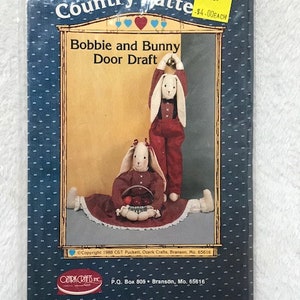 May include: A craft pattern for a Bobbie and Bunny door draft. The pattern is from Ozark Crafts Inc. and is priced at $4.00 each.