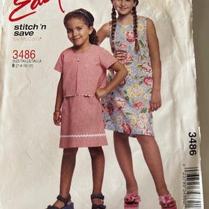 Puede incluir: Un patrón de costura para dos vestidos de niña. El patrón es para las tallas 7-8, 10 y 12. El patrón se llama "Easy Stitch 'n Save" de McCall's y el número de patrón es 3486.