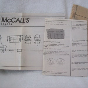 May include: A black and white sewing pattern for a utility apron with multiple pockets. The pattern is labelled "M4322 McCall's Crafts".