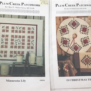 Può includere: Due modelli di trapunta, "Minnesota Lily" e "O Christmas Tree", di Plum Creek Patchwork. I modelli presentano tessuti rossi, verdi e bianchi.