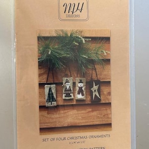 May include: A paper foundation pattern for four Christmas ornaments, each measuring 2 1/4 inches by 1/2 inch. The pattern is titled "MH Designs" and includes the number "MH 990".