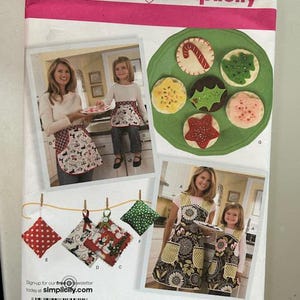 May include: Simplicity sewing pattern number 2492 for making Christmas aprons and hot pads. The pattern includes instructions for making two sizes of aprons and four hot pads. The hot pads are decorated with a variety of Christmas designs, including candy canes, holly, and snowflakes.
