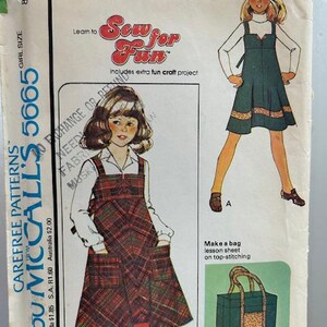 May include: Sew for Fun pattern for a girl's dress with a plaid skirt and a bag. The pattern includes instructions for making a bag with top stitching. The pattern is from McCall's and is size 5665.