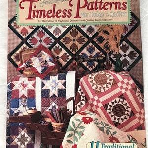 May include: A book titled "Favorite Timeless Patterns for Today's Quilter" by The Editors of Traditional Quiltuorks and Quilting Today magazines. The book features 11 traditional quilt patterns and includes a variety of colorful quilt blocks.