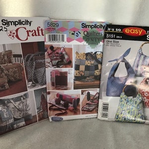 May include: Three Simplicity sewing patterns for bags. The first pattern is for a tote bag with a floral design. The second pattern is for a quilted bag with a patchwork design. The third pattern is for a hobo bag with a striped design.