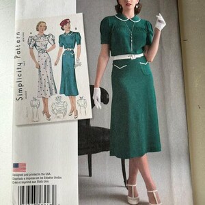 Può includere: Cartamodello Simplicity 8248 per un abito in stile vintage anni '30. La busta presenta una fotografia di un abito verde con colletto bianco, cintura bianca e guanti bianchi, insieme a illustrazioni di due varianti di abito e un codice a barre.