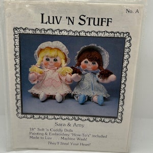 May include: A pattern for making two 18-inch soft and cuddly dolls named Sara and Amy. The pattern includes instructions for painting and embroidery. The dolls are wearing blue and white dresses with hearts on them. The pattern is titled "Luv 'N Stuff" and has the number "A" on it.