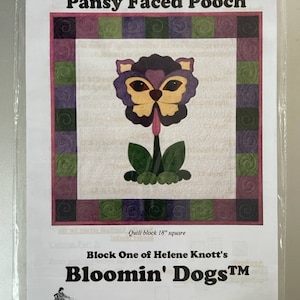 Pode incluir: Um padrão de acolchoado para um bloco de acolchoado quadrado de 45,7 cm que apresenta um cão com cara de pensamento. O padrão é intitulado "Pansy Faced Pooch" e faz parte da série "Bloomin' Dogs" de Helene Knott.